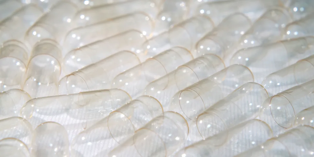 Clear empty capsules against a white background