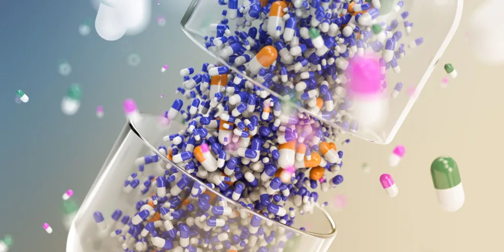 3D graphic of large clear capsule separating, containing several types of differently colored capsules.