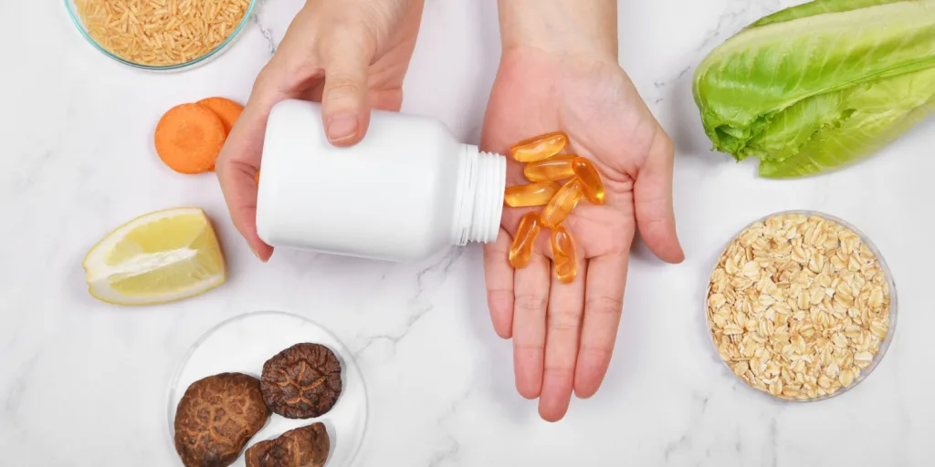 Pouring a bottle of gel-caps into an open hand surrounded by various foods.