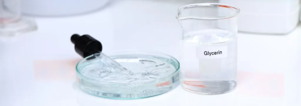 Container with glycerin alongside a petri dish with glycerin and a dropper in a laboratory setting.
