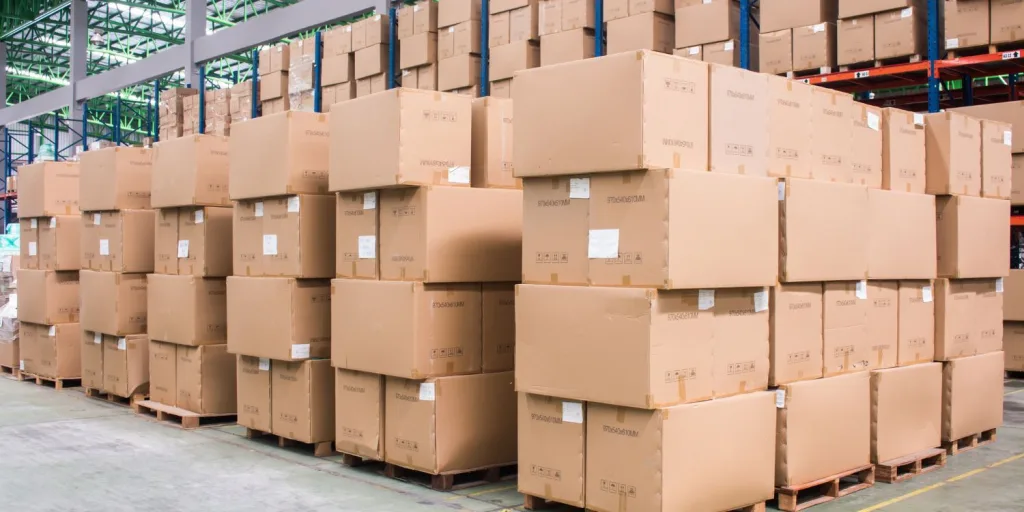 Stacks of bulk products in boxes on pallets and racks in a warehouse.