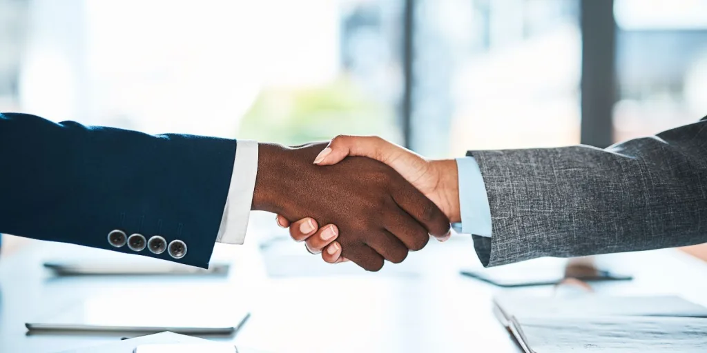 Close up of two hands shaking in a business setting.