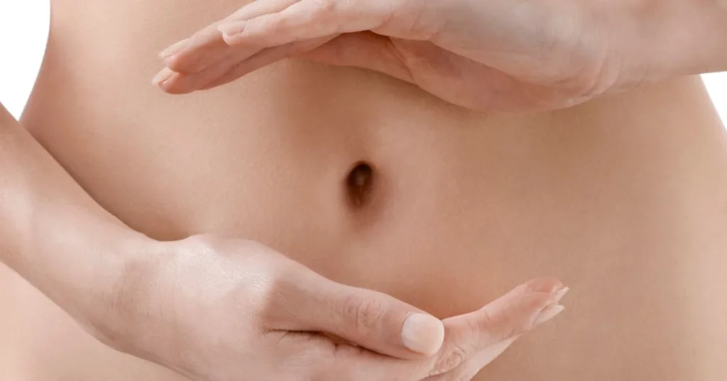 A close-up of a person's hands encircling their stomach.
