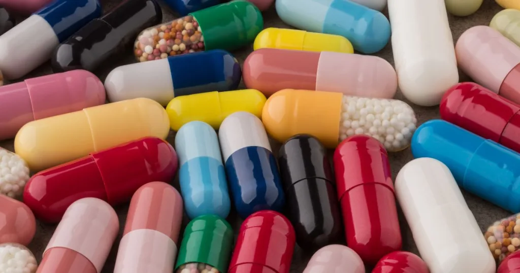 An assortment of different color capsules filled with different types of materials.