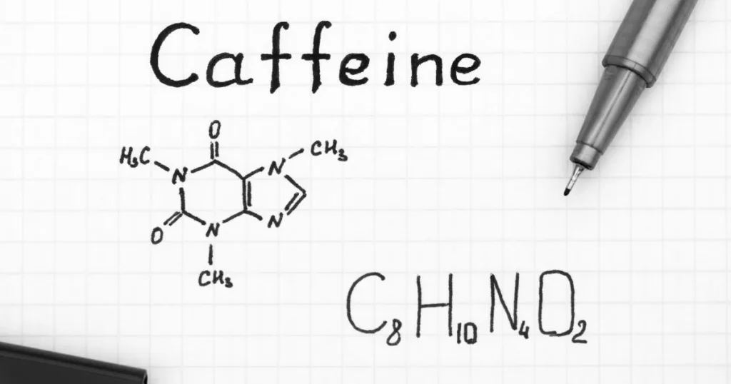 The word "Caffeine" written in think marker on graph paper, along with the chemical structure of Caffeine (C₈H₁₀N₄O₂).