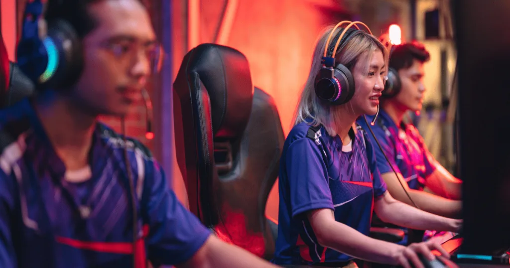 Esports athletes wearing headphones and mics and playing a game on their own separate computers.