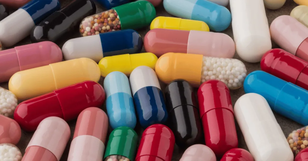 A close up of different capsules, some with two different colors, some clear with microbeadlets, some solid colors.