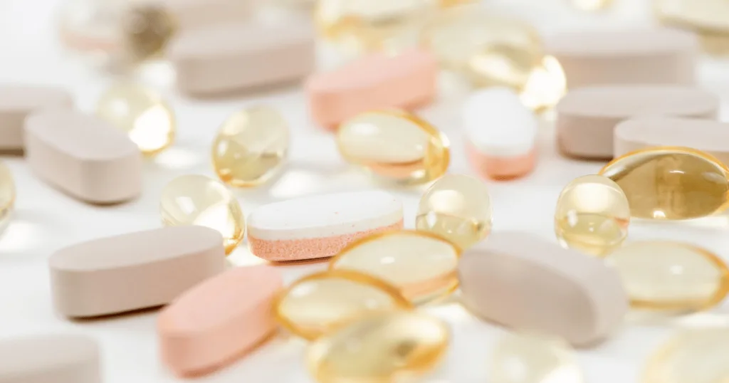 A close up shot of an assortment of women's health supplements, including tablets, soft gels, and capsules.