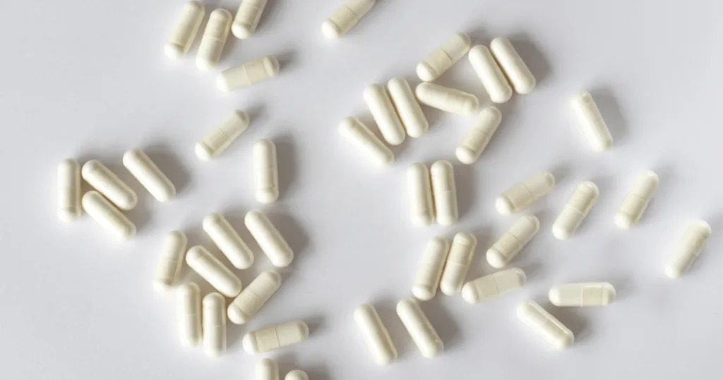 White capsules scattered against a white background.