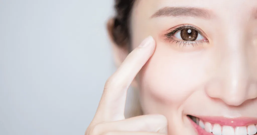 A close-up shot of a smiling woman's clear brown eye.