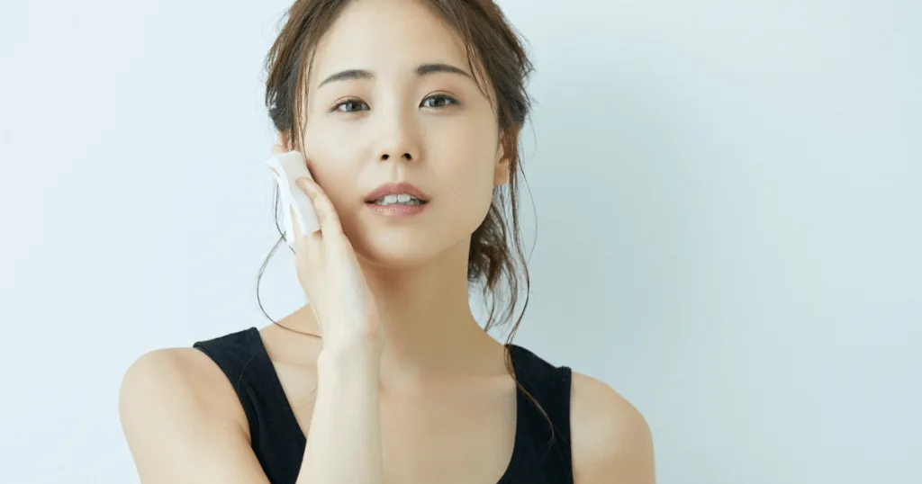 A young woman holding her hand to her face.