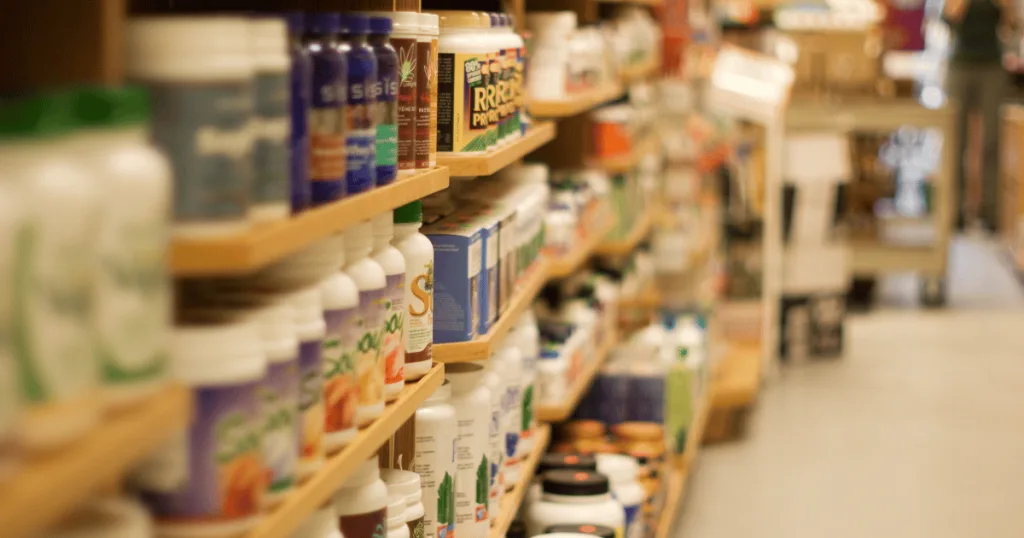 Packaged supplement products lined up on a shelf in a health food store.