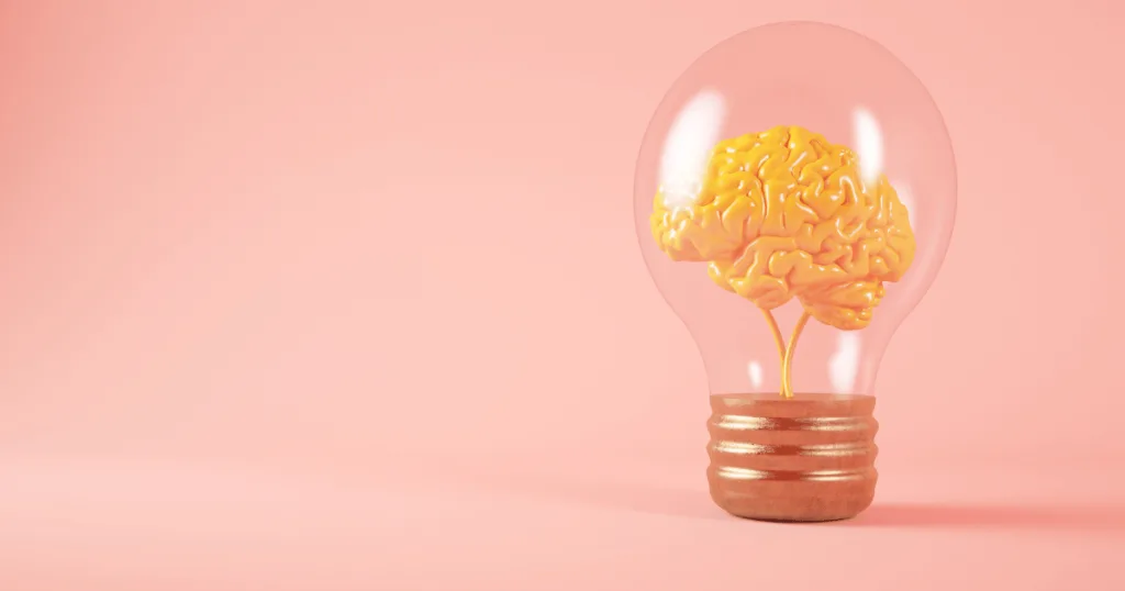 A 3D graphic of a yellow brain inside of a lightbulb against a pink background.