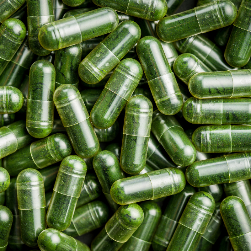 Clear capsules filled with green powder material.