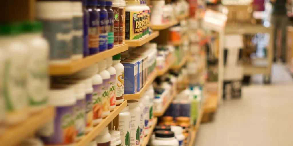 Bottles of supplements in shelves at a health store.